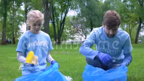 男志愿者和女儿一起收集垃圾林给高五视频的预览图