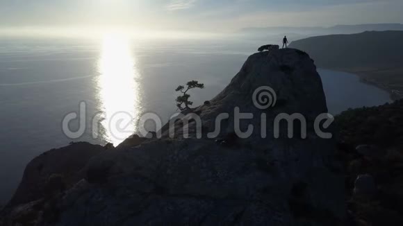 年轻女子在海面上的山顶上跳舞在美丽的风景中登上顶峰的女士视频的预览图