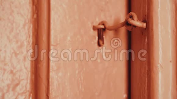 晚上一个男人手打开一扇锁在钩子上的房子里的木门白炽灯光木门是粉刷过的视频的预览图