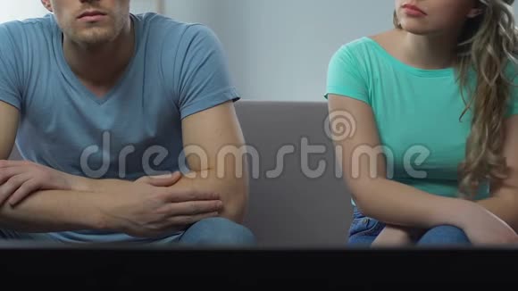 一对夫妇坐在电视前看比赛悲伤的女人看着男人视频的预览图