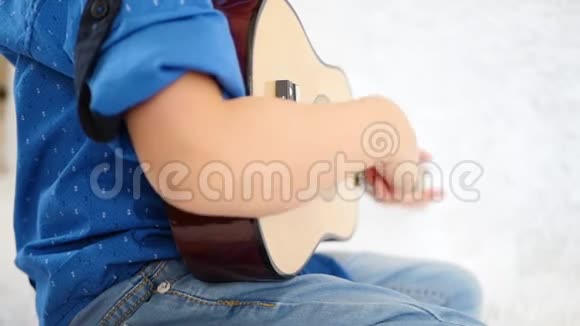 特写孩子的手小男孩在玩玩具吉他音乐教育生活方式游戏开发视频的预览图