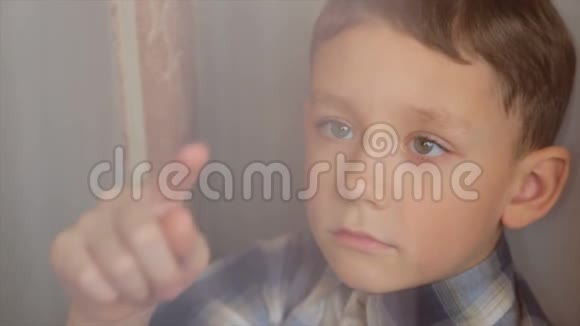 那个男孩用手指在窗户上视频的预览图