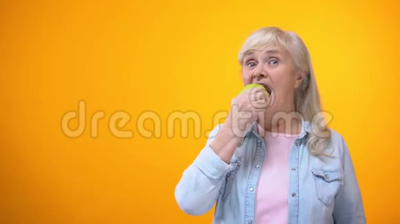 乐观的老太太咬鲜绿苹果健康的牙齿口腔科视频的预览图