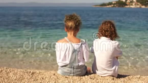 日落时小女孩和男孩牵手的背影爱情友谊的概念视频的预览图