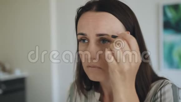 一个中年妇女在镜子前的房间里化妆视频的预览图