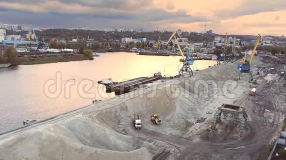 傍晚日落时分基辅第聂伯河货运码头重型起重机装载散装货物的鸟瞰图视频的预览图