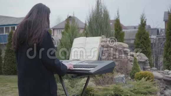 专业钢琴家在后院的合成器上演奏古典钢琴音乐真人秀系列视频的预览图