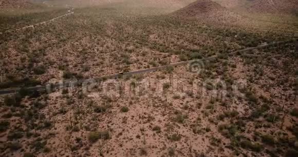 在史诗般的亚利桑那国家公园美国无人机在巨大的仙人掌田景中沿着沙漠道路行驶视频的预览图