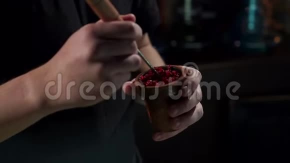 一个男人手把水果烟草放在一个石沙的碗里准备胡克视频的预览图