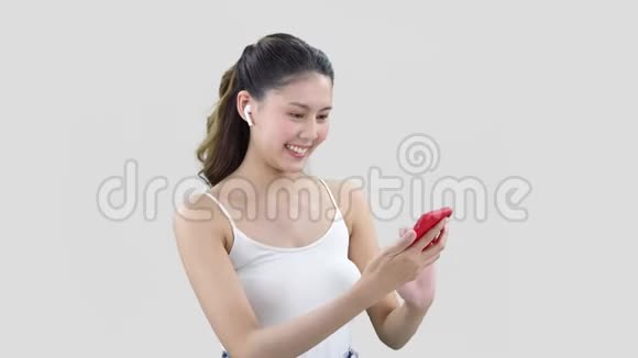 穿着白色上衣的长发女孩用红色手机和朋友发短信视频的预览图