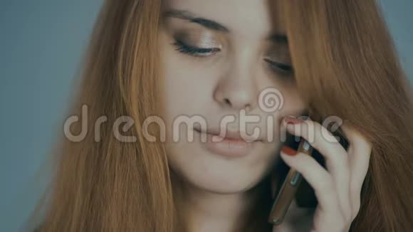 红发年轻女子在电话中交谈在演播室背景概念情感交流技术上微笑视频的预览图