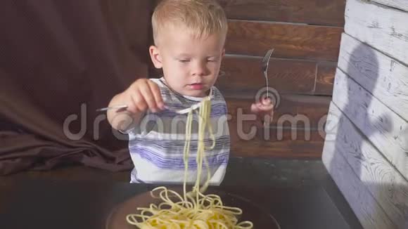 两只耳朵小孩在家吃意大利面或小孩餐馆慢动作视频的预览图