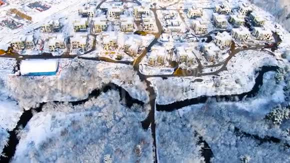 从空中俯瞰冬季工业城市景观旅途森林地区小镇寒冷季节的雪景视频的预览图