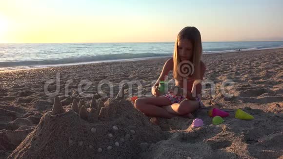 日落海滩儿童玩沙城堡海岸女孩4K视频的预览图