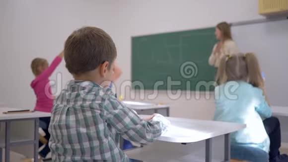 孩子们的教育孩子们在课堂上听老师在黑板上集中在学校的课堂上视频的预览图