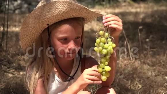 吃葡萄的儿童饥饿的小农家女孩在橄榄园吃水果4K视频的预览图
