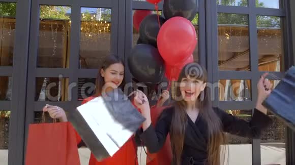 购物日快乐的女性朋友挥舞着袋子在黑色星期五的季节性销售中从时装店购买新产品视频的预览图