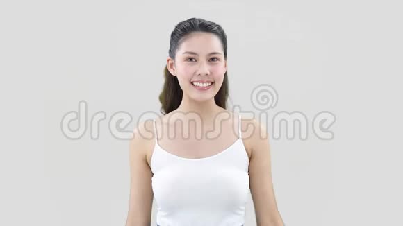 年轻的东方女人微笑着用OK的姿势举起双手复制空间视频的预览图
