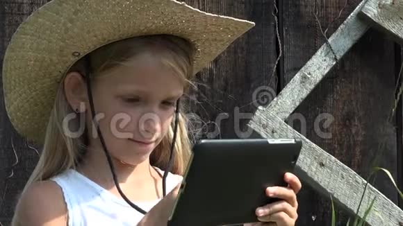 乡村儿童在户外玩平板游戏在自然4K放松乡村女孩视频的预览图