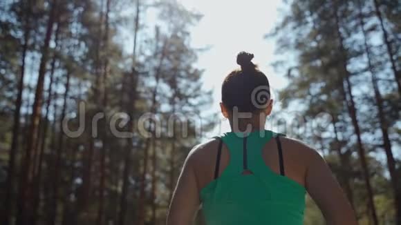 美丽的白种人女运动员在松林的柏油路上度过了阳光明媚的夏日健康生活方式视频的预览图