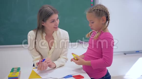 快乐职业教师女性画像聪明的小女孩手里拿着塑料数字就在黑板旁边视频的预览图