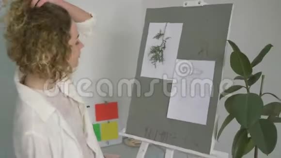 创作艺术家的肖像妇女用铅笔在画架上画素描以实现工作室的艺术理念视频的预览图