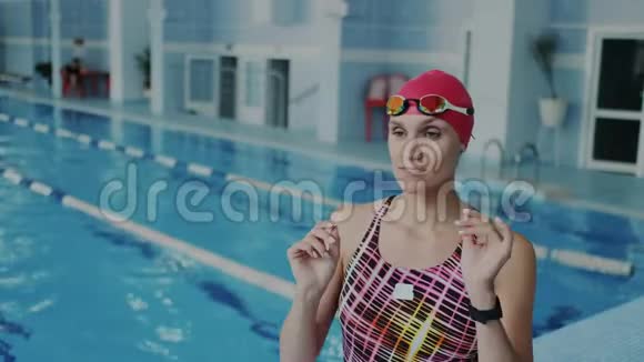 年轻的职业女游泳运动员戴着护目镜在水下漂浮她穿着泳衣和红色视频的预览图