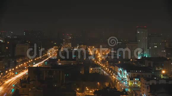 一座城市的灯光和汽车在道路上行驶现代建筑的夜灯从酒店阳台上观看时间视频的预览图