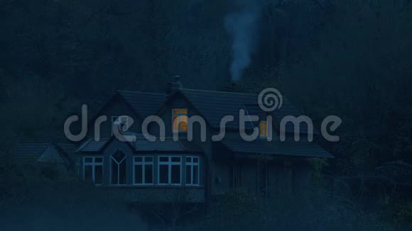 树林中的房子黄昏时有吸烟烟囱视频的预览图