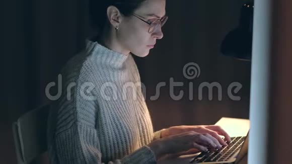 漂亮的女人晚上在电脑上工作视频的预览图