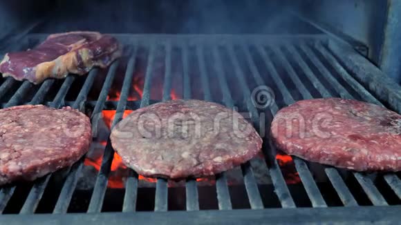 三份肉排和牛排在烤架上特写背景是烤过的煤和烟视频的预览图