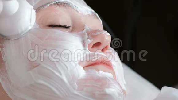 一个完整的女人的面部特写一个程序一位戴着白手套的专业美容师的手滑了下来视频的预览图
