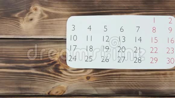 木制背景上的白色日历表视频的预览图