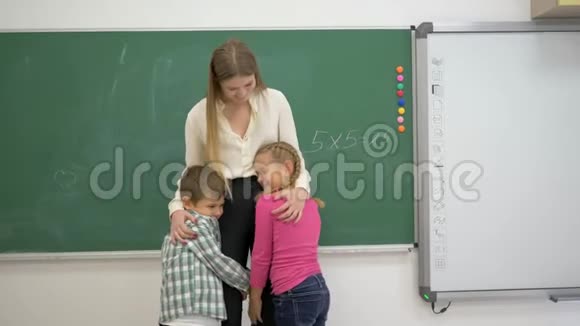 微笑教室教师与学生在黑板附近拥抱的画像视频的预览图