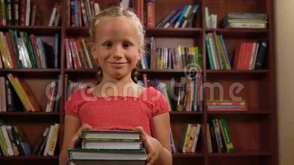 六岁的女孩站着看书微笑着视频的预览图