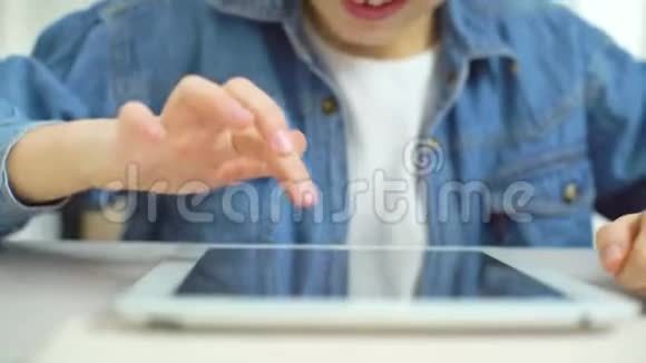 小女孩在玩游戏时用手指触摸平板电脑屏幕视频的预览图