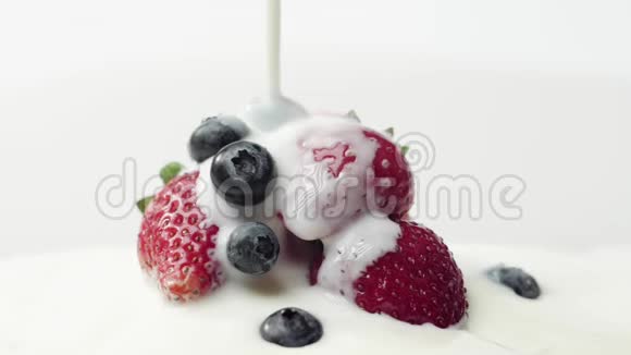 新鲜健康食品草莓和蓝莓倒入酸奶酸奶和鲜奶油中的浆果新鲜水果视频的预览图
