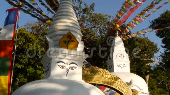 在阳光下寺庙的彩色雕塑白石塔雕塑花环下装饰着五颜六色视频的预览图