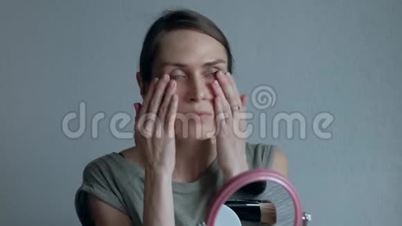 女人把奶油粉底涂在脸上女性在家的平凡日子视频的预览图