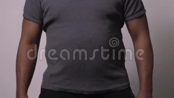 非裔美国人男式提升衬衫展示大腹便便和爱情手柄视频的预览图