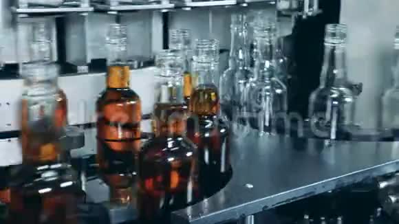 装有饮料和空瓶的玻璃瓶正沿着传送带移动视频的预览图