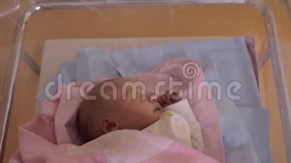 一个刚出生的小女孩睡在移动的医院婴儿车里视频的预览图