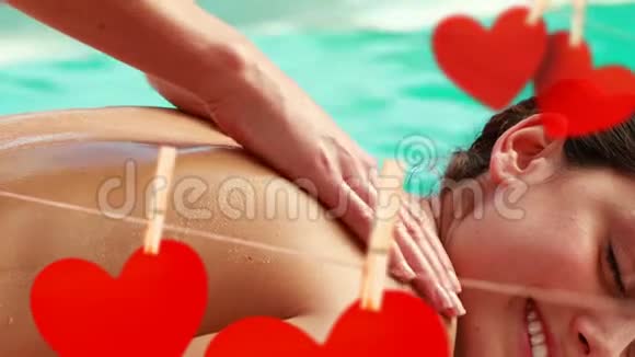 在泳池边用可爱的红纸心按摩情人节视频的预览图