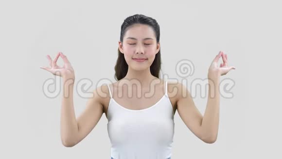 冷静的女孩黑发瑜伽姿势灰色背景握住手指在一起视频的预览图