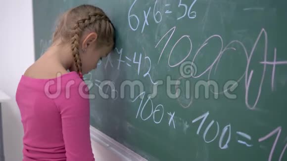 上学时女学生厌倦了站在黑板旁边的数学例子视频的预览图