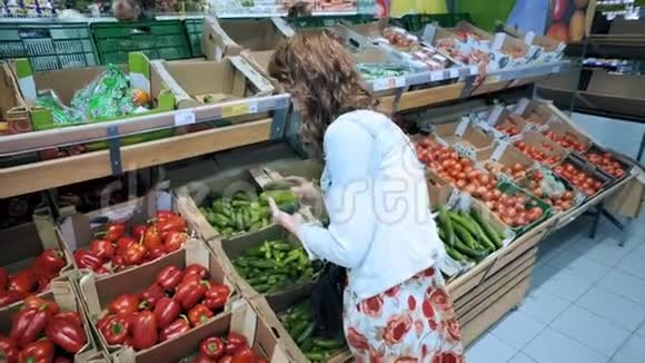 年轻女子在杂货店选择蔬菜视频的预览图