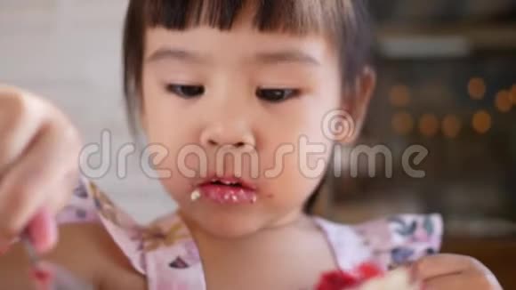 可爱的亚洲小女孩和她的家人在咖啡馆里吃桑葚蛋糕视频的预览图