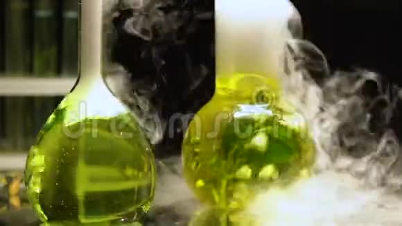 烧瓶中的化学液体在黑暗背景下沸腾释放烟雾提取视频的预览图