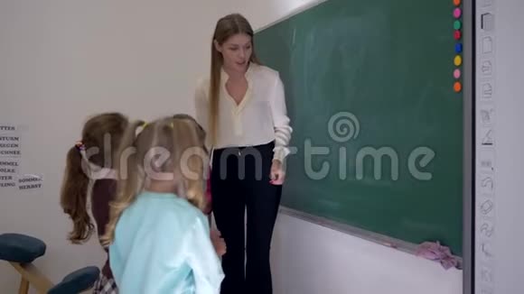 学生和老师站在教室的白板旁边女学生拿着一支粉笔里写答案视频的预览图