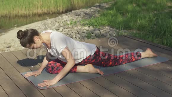 年轻女子在夏日的垫子上做瑜伽练习视频的预览图